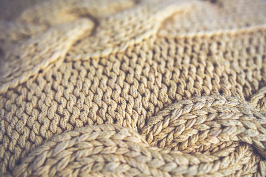 Gemütlicher Strickpullover und Schal auf Holz