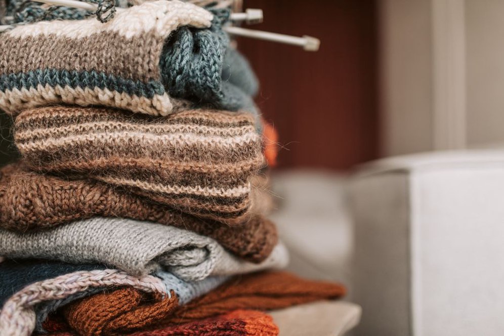Großer Grobstrickpullover auf einem Tisch