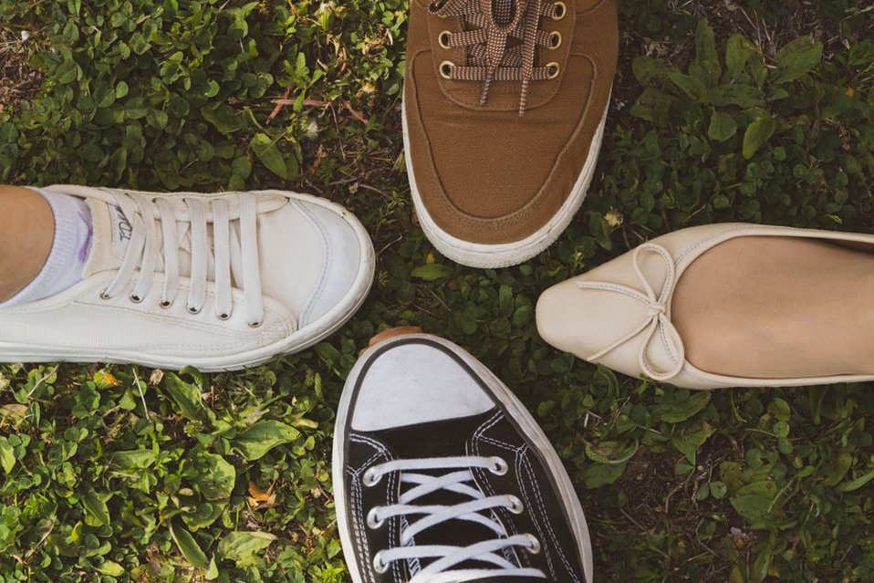Flache Schuhe neben Jeans und leichtem Strick