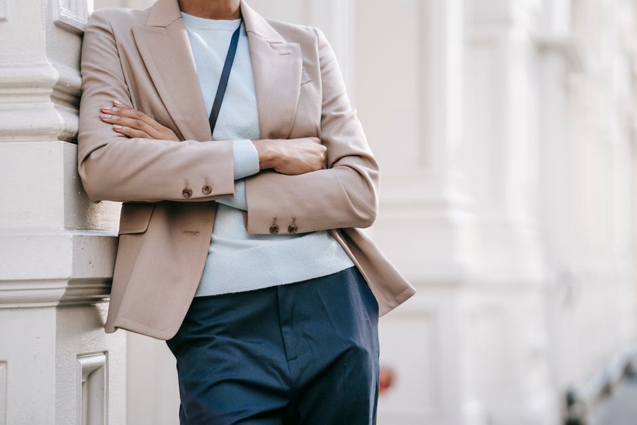 Dunkelblauer Blazer über hellem Oberteil und Stoffhose