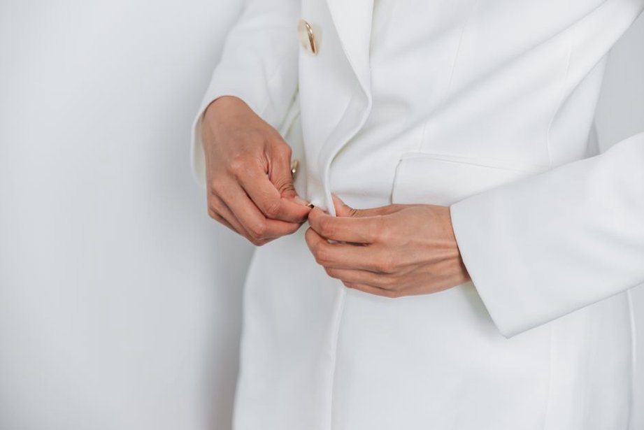Hände prüfen die Naht eines gebrauchten Blazers