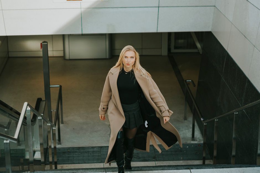 Dunkle Jeans und Stiefeletten unter einem Wollmantel