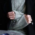 Hemdkragen und Pullover unter einem dunklen Wintermantel