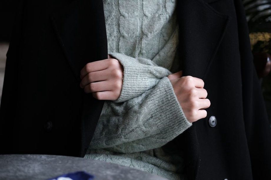 Hemdkragen und Pullover unter einem dunklen Wintermantel